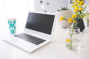 Laptop with coffee and flowers