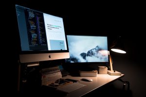 Dimly lit workspace with dual monitors